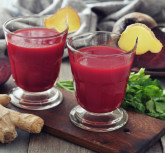 Beetroot smoothie in glass with ginger and  fresh vegetables on wooden background