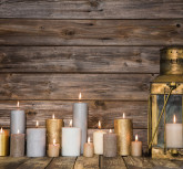 Wooden vintage background in with many burning candles and a old rustic lantern.