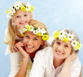 Portrait of daughter over her mother and grandmother with flowers on their heads