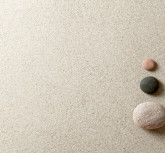 Three colorful zen stones at right side of sand background